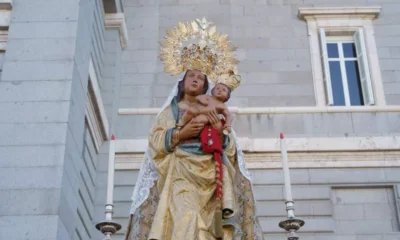 Imagen de la Virgen de la Almudena con dos candelabros a los lados