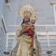 Imagen de la Virgen de la Almudena con dos candelabros a los lados