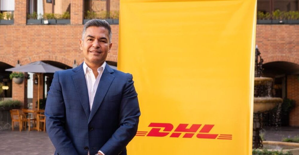 Representante de DHL Express delante de cartel de la compañía