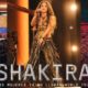 La cantante Shakira en el cartel de la gira , con micrófono y bandera de Colombia al fondo