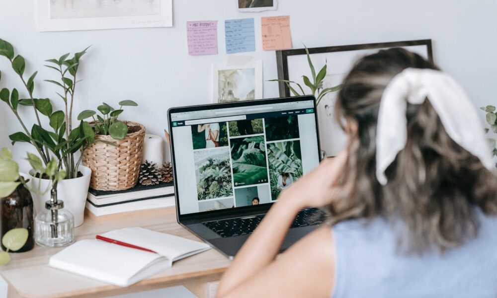 Mujer en escritorio sentada frente a ordenador mirando fotografías