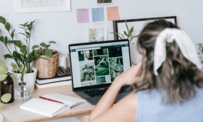 Mujer en escritorio sentada frente a ordenador mirando fotografías