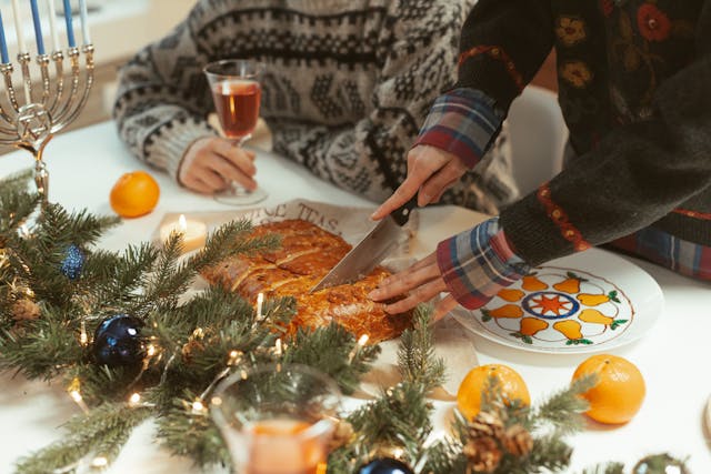 Mujer cortando un plato de comida en una mesa navideña